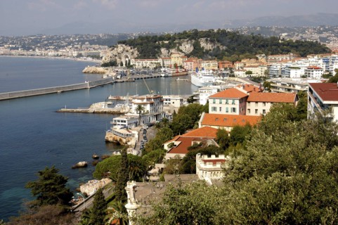 FRANCE, Cote d Azur, Nice, View over rooftops and harbour with the coastline beyond