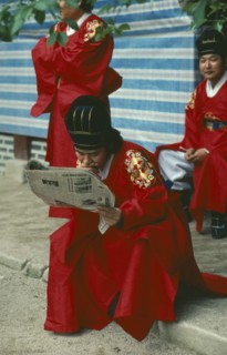SOUTH KOREA, Seoul, Confucian devotee reading a newspaper during break from rites.