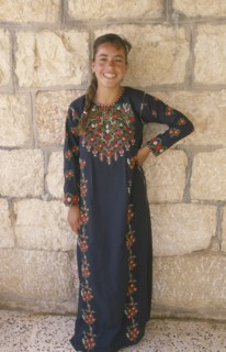 WEST BANK, People, Young woman in traditional Palestinian embroidered dress in National colours