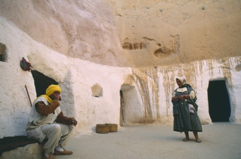 TUNISIA, Matmata, Couple at entrance to cave homes.
