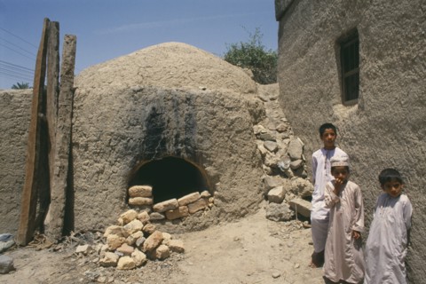 OMAN, North, Bahla , Children standing beside kiln.