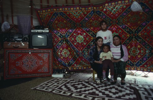 MONGOLIA, People, Mongolian mother and children inside a yurt sitting beside stereo and television