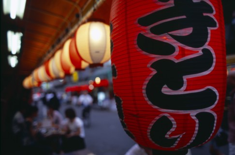 JAPAN, Honshu, Tokyo, Close up view along a row of lanterns illuminated outside an Asakusa area