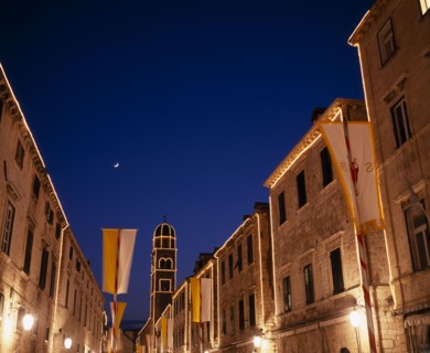 CROATIA, Dalmatia, Dubrovnik, View along the Stradun toward the Franciscan Monastery illuminated at