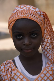 NIGERIA, Kano, Portrait of girl wearing orange headscarf