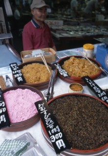 JAPAN, Honshu, Tokyo, Tsukiji Fish Market stall with variety of seafood items on dispay and vendor