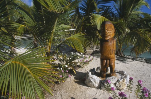 PACIFIC ISLANDS, Cook Islands, Aitutaki, Carved wooden sacred statue standing on a stone base