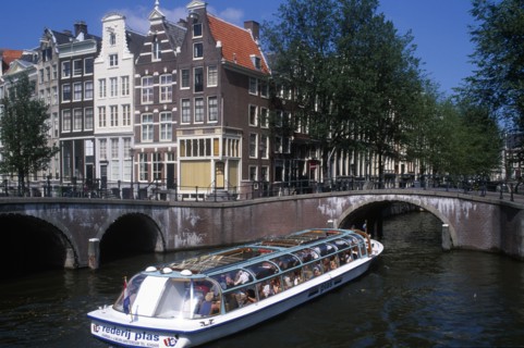 HOLLAND, Noord, Amsterdam, Tourist boat passing under a bridge on the Keizersgracht canal