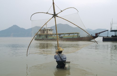 CHINA, Hubei Province, Yichang, Man fishing in the Yangtze River