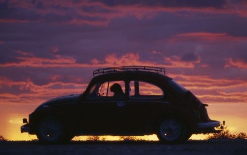 NAMIBIA, Transport, VW Beetle in silhouette against dramatic sunset sky.