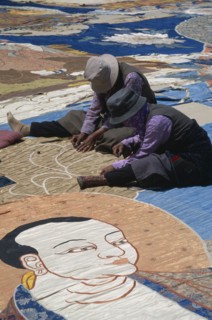 CHINA, Tibet, Lhasa, Potola Palace.  Workers sewing huge Buddha Tankha spread out on floor.
