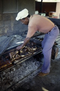 WEST INDIES, Jamaica, "Food	", Man cooking jerk pork over an open fire