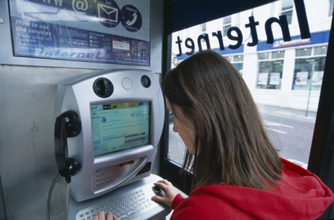 COMMUNICATIONS, Phone Box, Young woman using a public BT Internet phone booth.