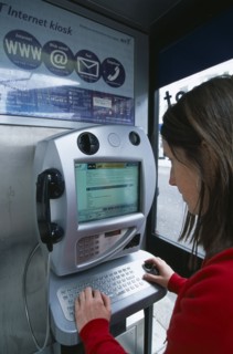 COMMUNICATIONS, Phone Box, Young woman using a public BT Internet phone booth.