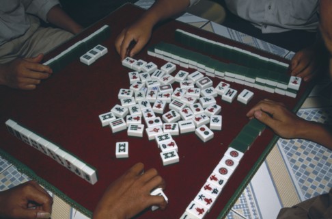 CHINA, Yunnan, Mah Jong game being played with view over peoples hands on a tiled table.