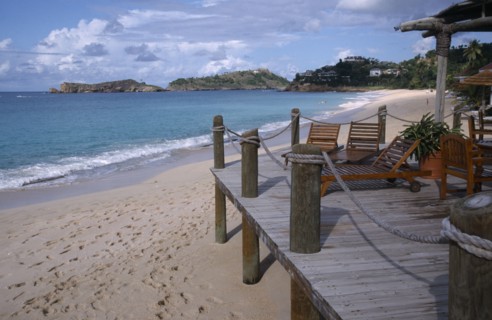 WEST INDIES, Antigua, Galley Bay, View along the beach from a wooden hotel beach terrace