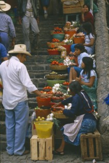 MEXICO, Market Scene, Girls selling fruit and vegetables on stone steps of market.