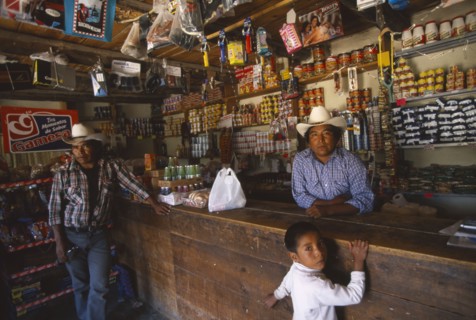 MEXICO, Chihuahua, Cusarare, Tarahumara Indian shopkeeper and customers at wooden counter inside