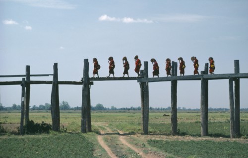MYANMAR, Amarapura Bridge, Line of monks crossing two hundred and fifty year old bridge over flood