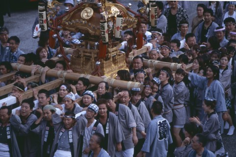 JAPAN, Honshu, Tokyo, Shinjuku. Crowd of people carrying Mikoshi throught the street during a