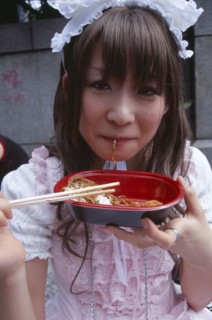JAPAN, Honshu, Tokyo, Harajuku District. Portrait of young teenage girl eating noodles