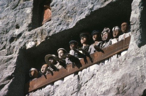 INDONESIA, Sulawesi, Toraja wooden funeral effigies or tau tau in cliff graves.  The figures