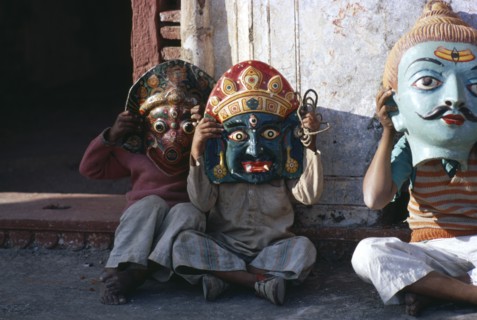 INDIA, Festival, Small children sitting in street wearing huge masks.