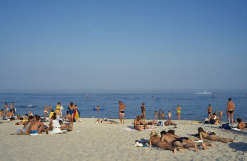 UKRAINE, Odessa, People sunbathing on sandy beach beside the Black Sea.