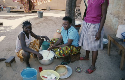 BURKINA FASO, Ouagadougou, Girls stirring milk.