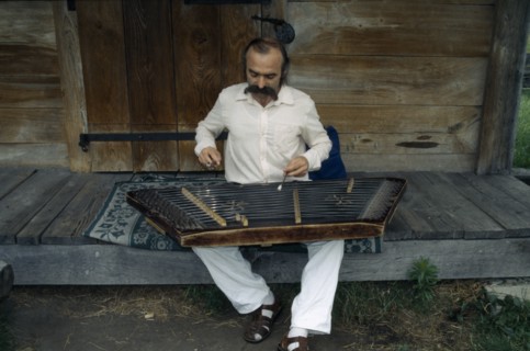UKRAINE, Kiev, Man playing zither like instrument called a dulcimer.