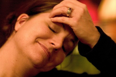 USA, Minnesota, St Paul, Woman aged 35 smiling and relaxing with her hand on her forehead and her
