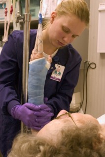 USA, Minnesota, Plymouth, Clinic nurse forming cast on arm of elderly patient with broken wrist.
