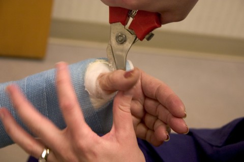 USA, Minnesota, Plymouth, Clinic nurse making adjustments to cast with cutter for patient with a