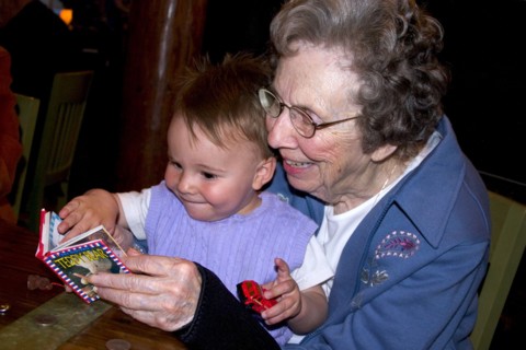 USA, Minnesota, Plymouth, Great grandmother reading book to great grandson in Red Lobster