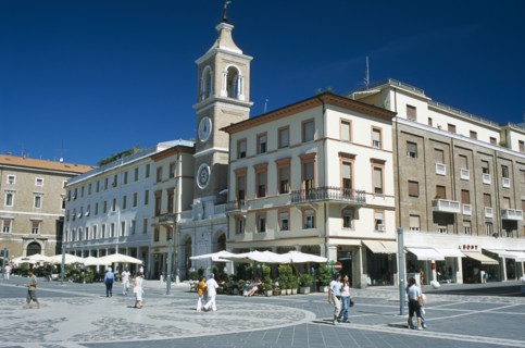 ITALY, Emilia-Romagna, Rimini, Town square with church and clock tower and cafes with outside