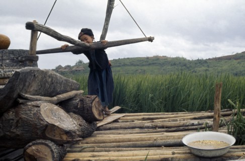 LAOS, Work, Meo girl grinding flour in village near Luang Prabang.