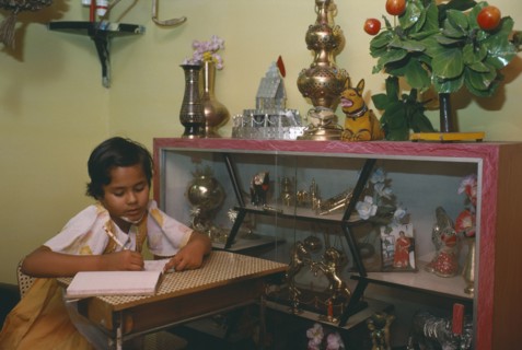 INDIA, Madhya Pradesh, Education, Ten year old girl doing homework in sitting room of middle class