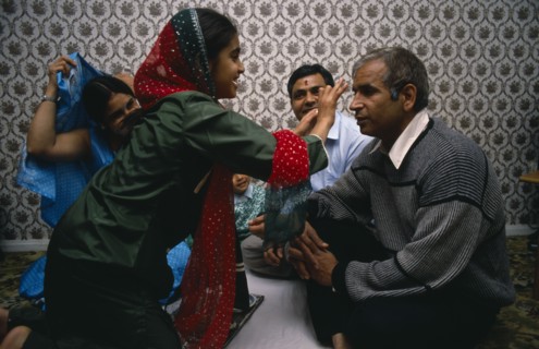 ENGLAND, Religion, Hindu, Daughter placing red mark on the forehead of her father during Hindu