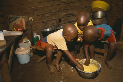 TANZANIA, West, Great Lakes Region, Refugee children eating maize porridge.