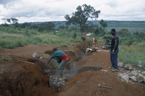 TANZANIA, West, Great Lakes Region, Refugees making gambions to prevent water erosion.  Base of