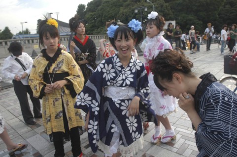 JAPAN, Honshu, Tokyo, Harajuku. Members of Kyoto Rokumeikan relax after dancing at the entrance of