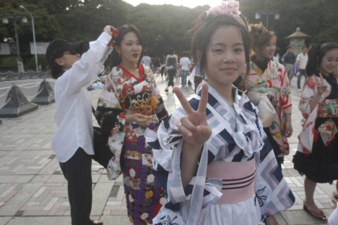 JAPAN, Honshu, Tokyo, Harajuku. Members of Kyoto Rokumeikan relax after dancing at the entrance of
