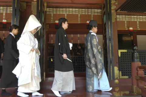 JAPAN, Honshu, Tokyo, Nezu. Shinto priest leads newly married couple out of Nezu Jinja shrine after