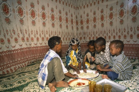 SOMALIA, Baidoa, Children eating meal at home from communal dish using the right hand.  At a family
