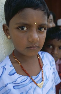 SRI LANKA, Dambetenne, Portrait of a young schoolgirl wearing gold jewellery