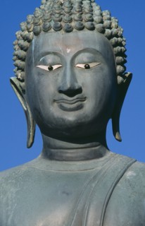 SRI LANKA, Colombo, Seema Malakaya on Beira Lake. Face of a Buddha statue against a blue sky