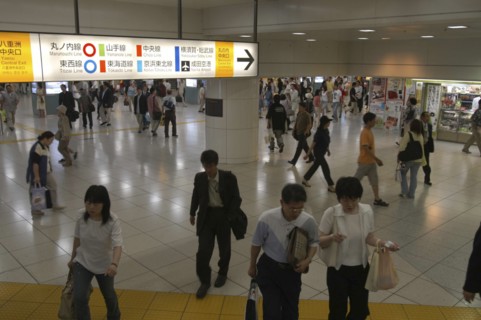 JAPAN, Tokyo , Tokyo station interior with crowds and bilingual color-coded signs above