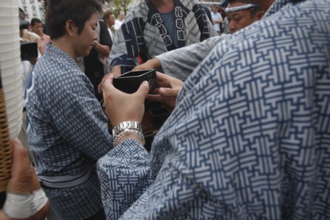JAPAN, Chiba, Narita, "Traditional woden square cup for drinking sake, held by man in traditional