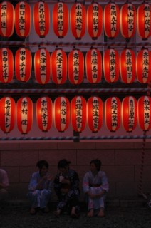 JAPAN, Chiba, Narita, "Teenage girls in yukata, summer kimono, sit beneath chochin lanterns each