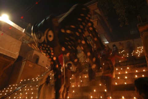 INDIA, Uttar Pradesh, Varanasi, Deep Diwali Festival. Men carry a paper statue of the Hindu God